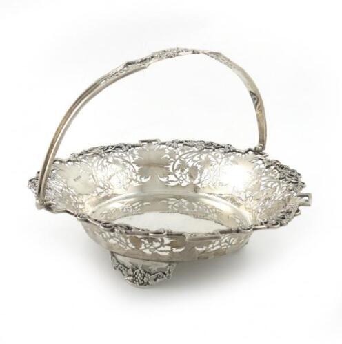 A silver swing-handled basket, by Poston Products Ltd, Sheffield 1962, circular form, pierced and engraved with trailing vine decoration, on three pierced bracket feet, diameter 28cm, approx. weight 27oz.