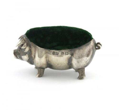 An Edwardian novelty silver pig pin cushion, by Levi and Salaman, Birmingham 1905, modelled in a standing position, green velvet cushion, length 5.5cm.