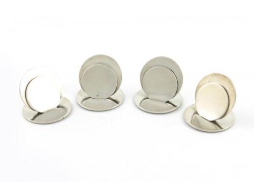 A set of four silver menu card holders, by Richard Woodman Burbridge for Harrods, London 1935, plain circular disc form, on circular bases, approx. weight 3oz. (4)