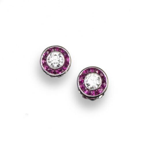 A pair of ruby and diamond ear studs, the circular-cut diamonds are set within a surround of tapered French-cut rubies in white gold, 7mm diameter